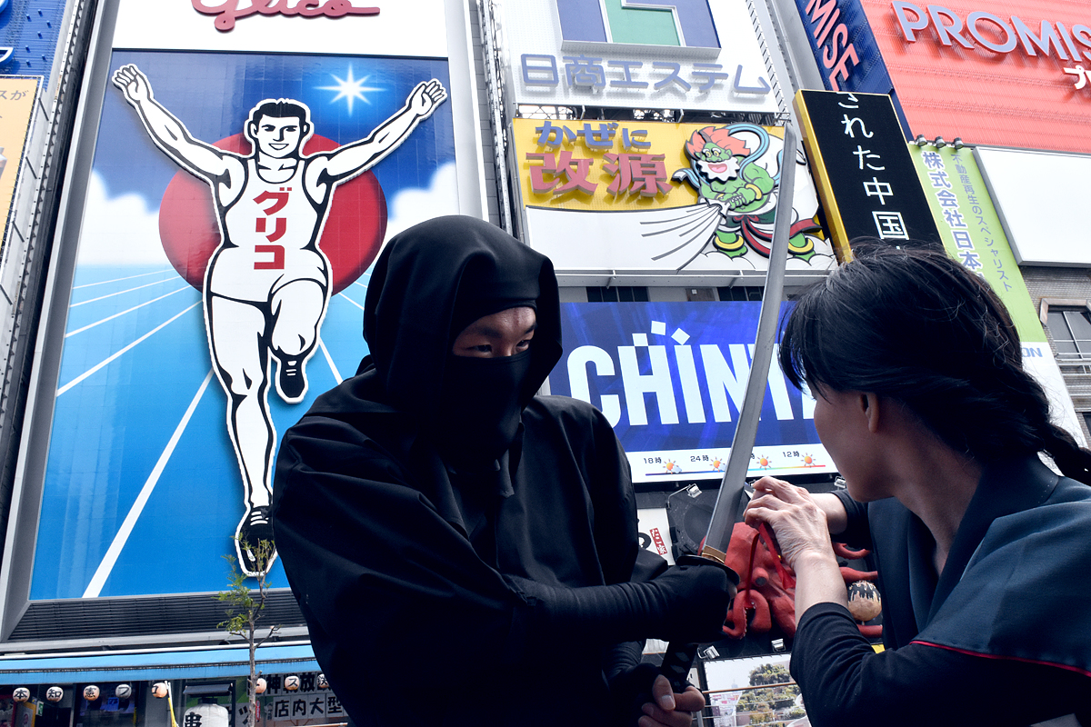 道頓堀の看板をバックに忍者衣装で記念撮影